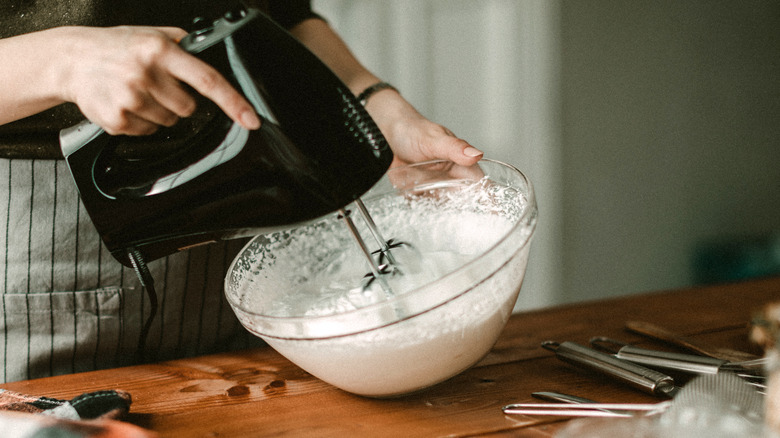 person using mixer for whipped cream