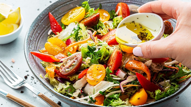 Pouring dressing over salad