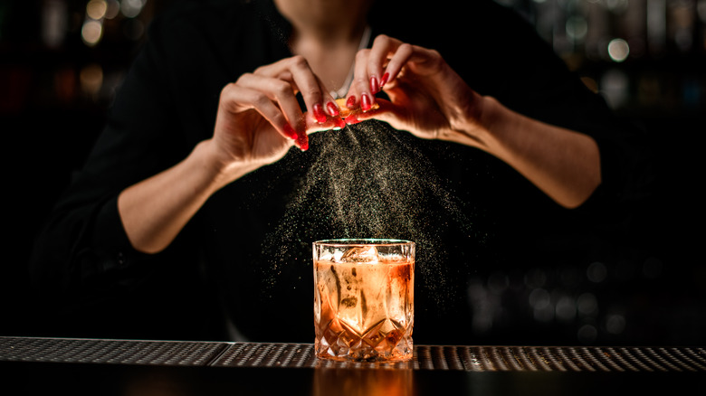 bartender garnishes old fashioned