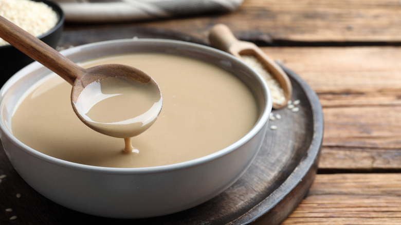 Spoon dipping into tahini sauce