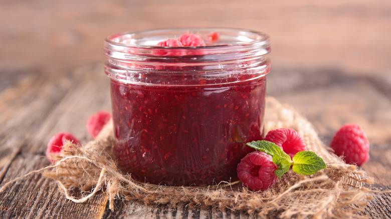 Jam and raspberries against wood