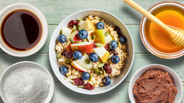 Overnight oats surrounded by various ingredients and toppings