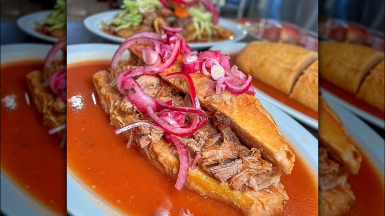 Carnitas torta with pickled onion