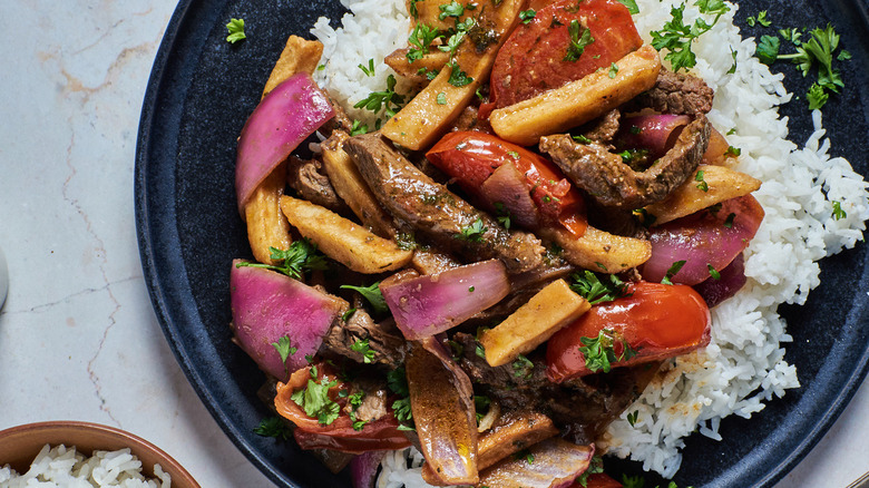 beef with fries, rice, and vegetables on a plate