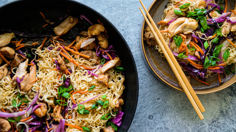 stir-fry in skillet and plate with chopsticks