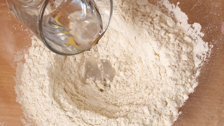 Pouring water into dough