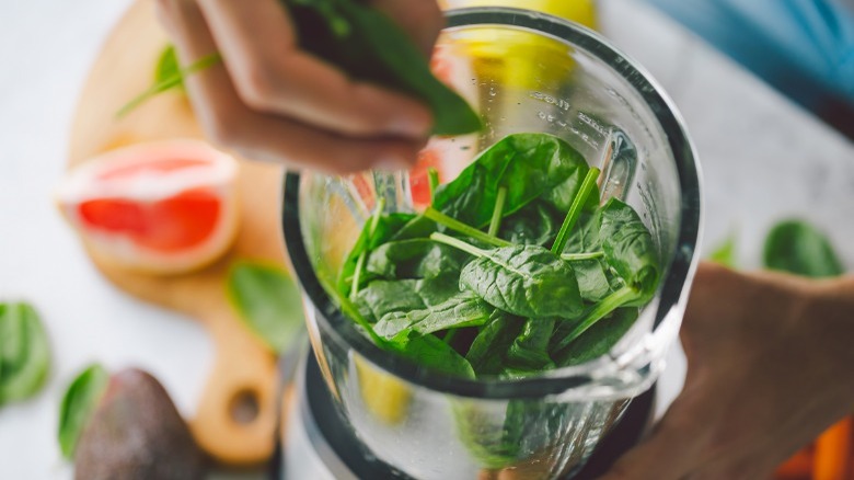 putting spinach into blender