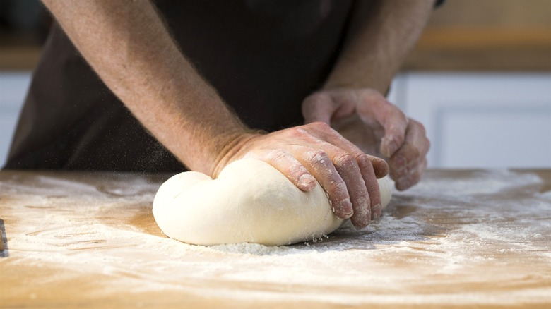 Hands kneading dough ball