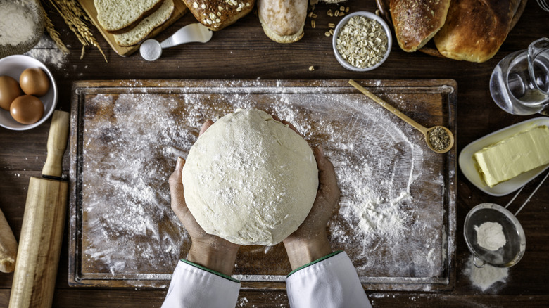 Chef's hands holding pizza dough