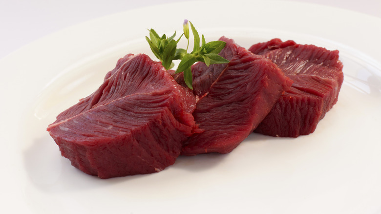 Ostrich filets on white plate