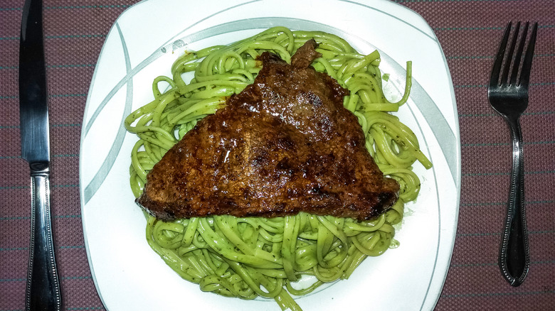 green noodles topped with liver 