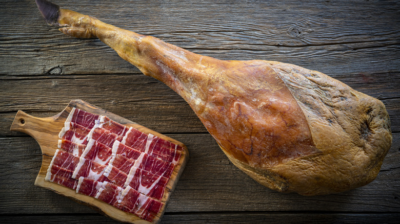 sliced jamon iberico next to ham leg