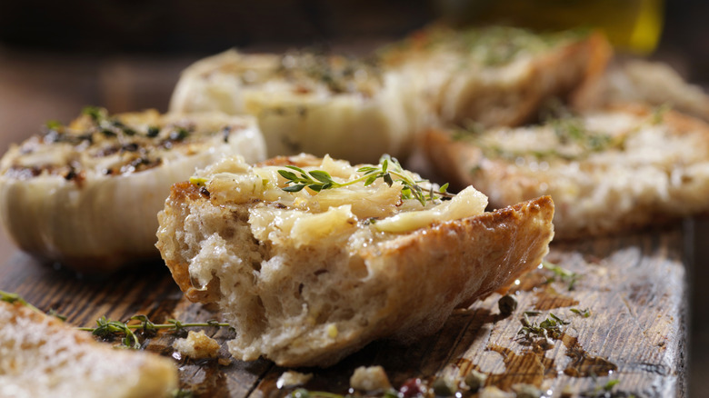 Slices of rustic garlic bread on a wooden table