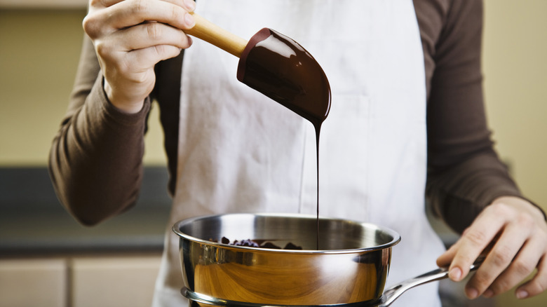 woman spooning melted chocolate