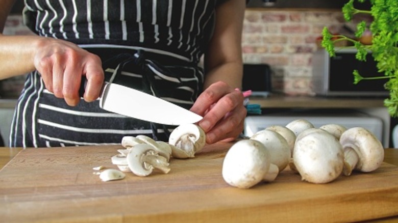 Hands cutting mushrooms