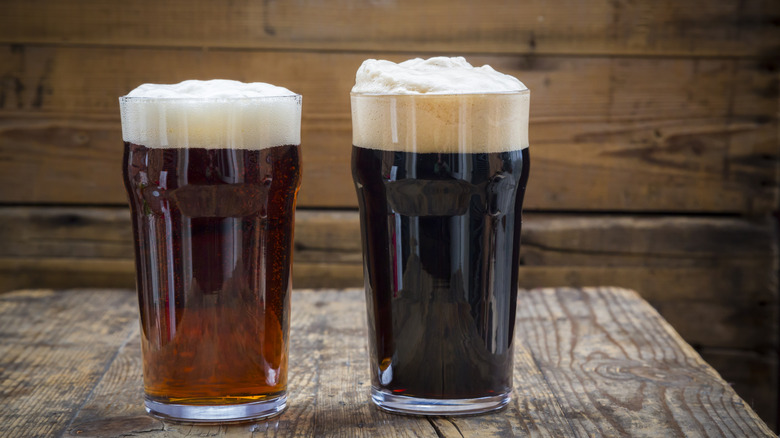 A pint of brown ale and a pint of stout side by side on a table