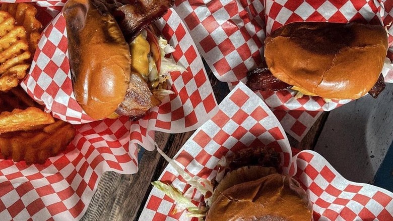 three burgers in red and white checked paper