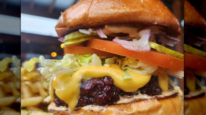 cheeseburger topped with tomato