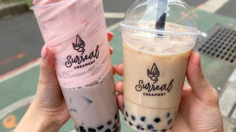 people holding boba drinks