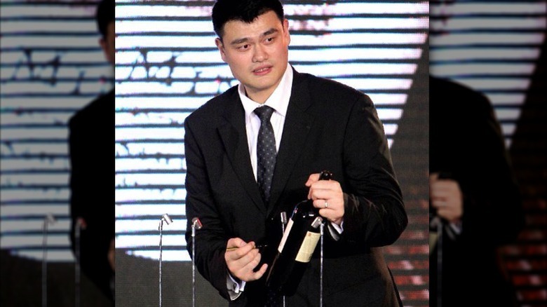 Yao Ming holding wine bottle