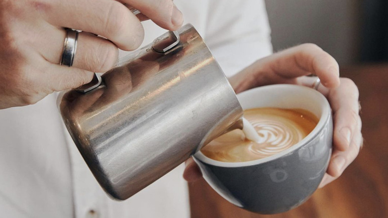 Barista pouring milk