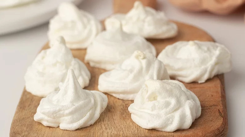 Piped meringue cookies on wood block