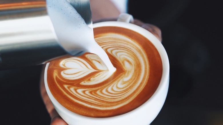 Pouring milk into coffee cup