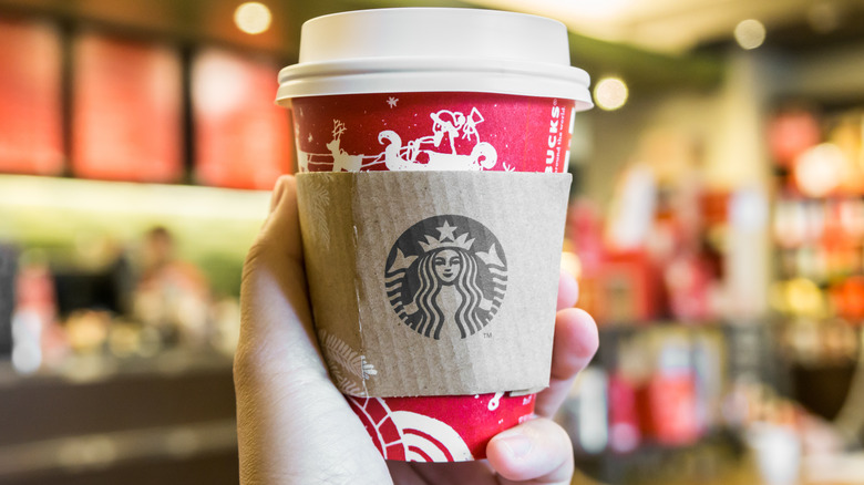 hand holding Starbucks holiday cup