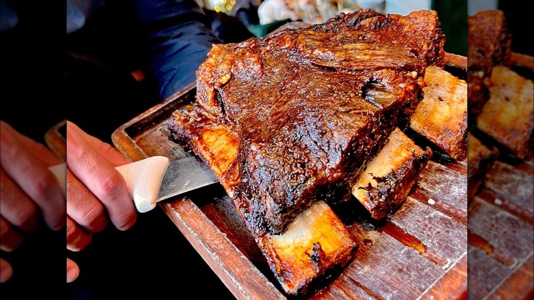 person serving steak with knife and board