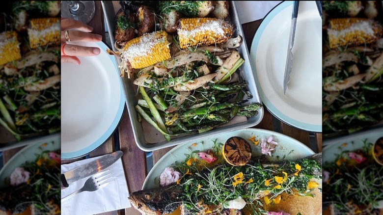 plates of vegetables and fish on wooden table