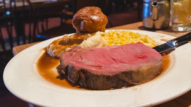 Prime rib with mashed potato and sides on plate