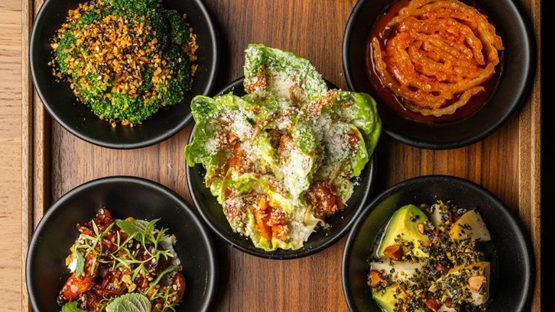 Banchan in bowls on wooden tray