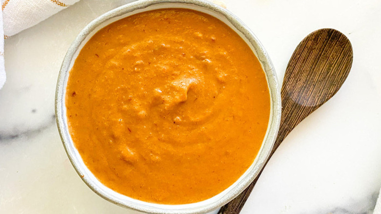 Bowl of spicy peanut sauce with spoon
