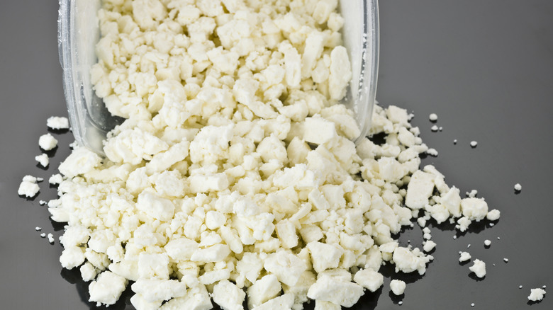 Crumbled feta cheese pouring