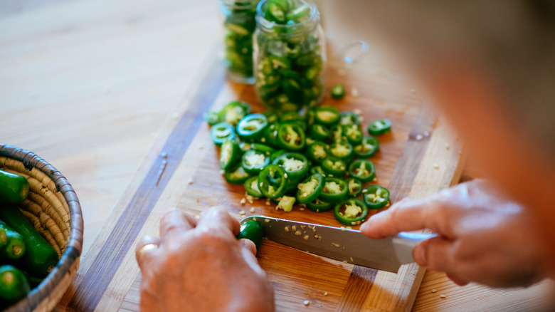 Person slicing jalapeño peppers