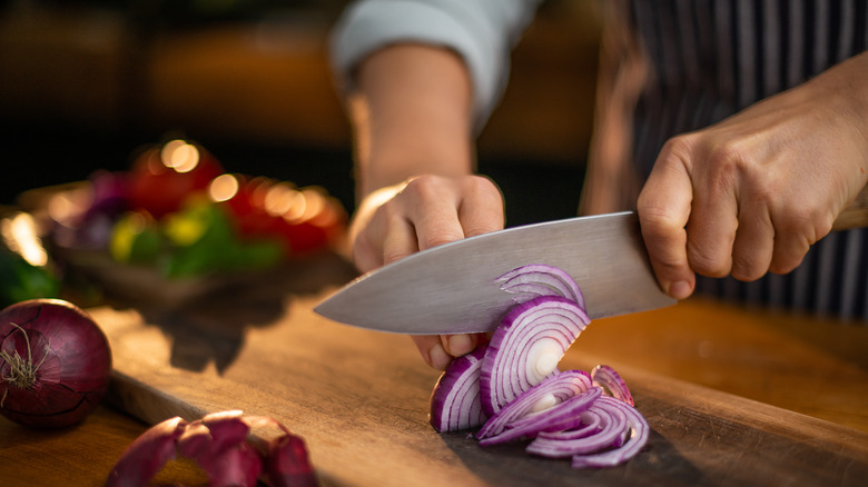 Person chopping red onions 