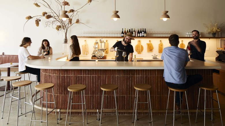 Bartender pouring glass of wine at Golden Age Wine