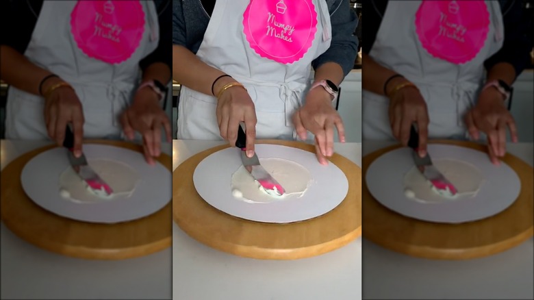 applying buttercream to cake board