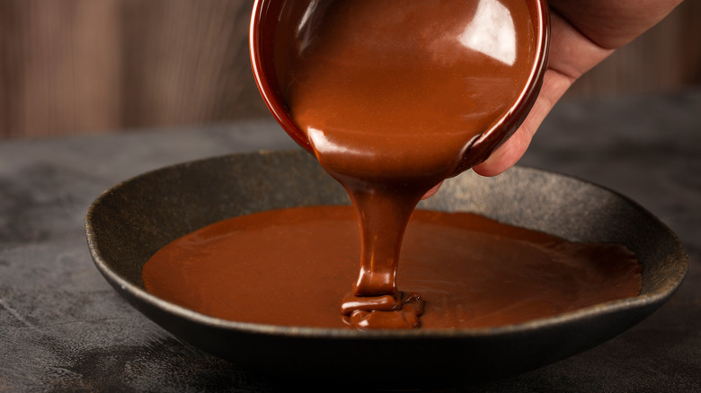 pouring chocolate ganache into dish