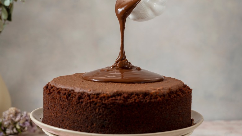 Pouring chocolate sauce on cake