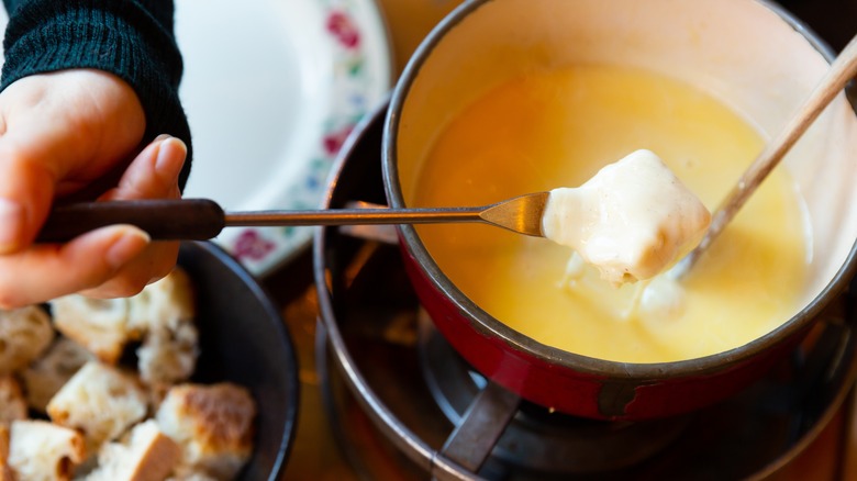 Dipping bread in fondue Savoyarde