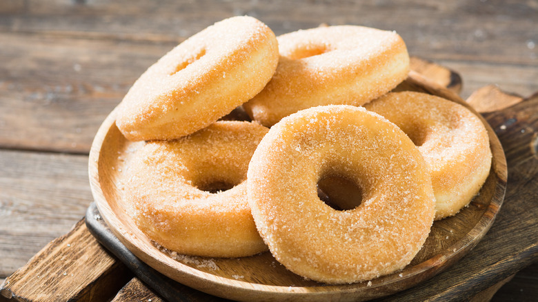 Sugar-covered donuts on plate 