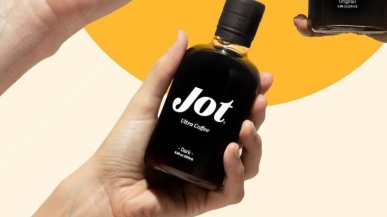 Person holding Jot coffee bottle