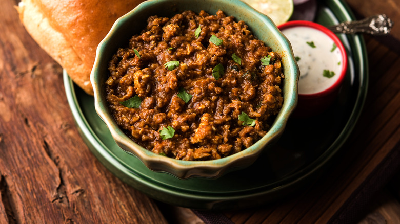 Keema minced meat in a bowl with bread and toppings