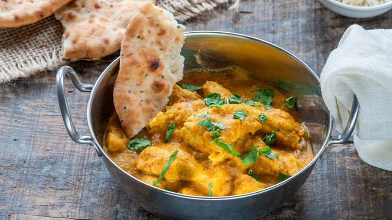 Korma curry with naan bread in a bowl