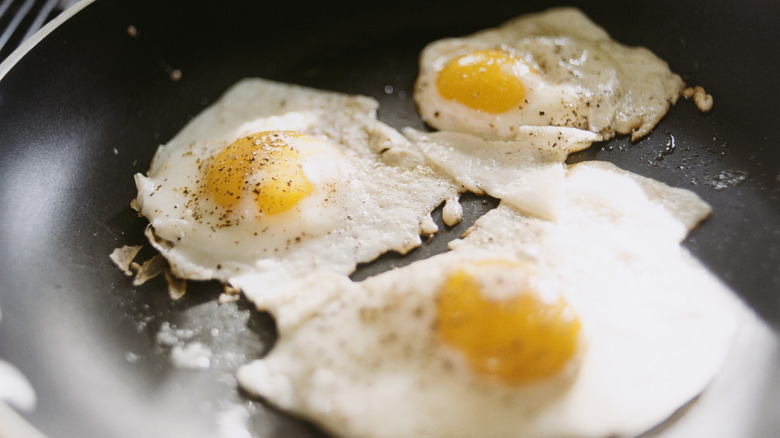 Three fried eggs in nonstick frying pan