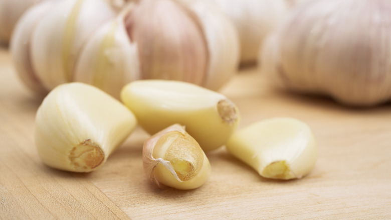 Cloves of whole garlic on cutting board