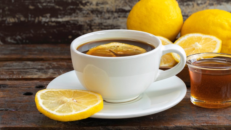 A cup of black coffee with lemon slices