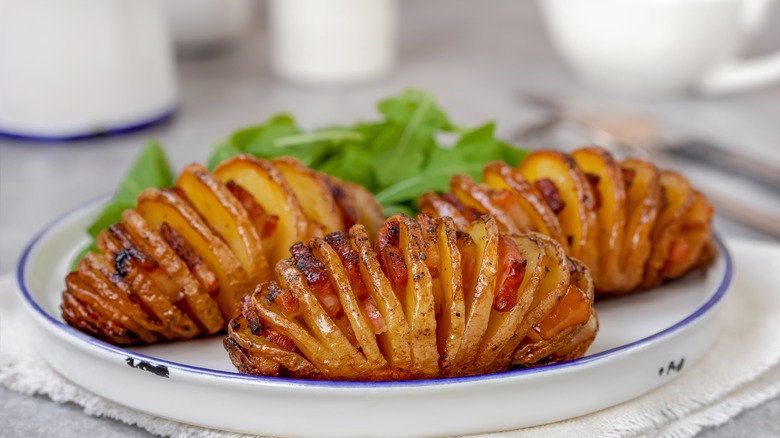 three Hasselback potatoes on plate