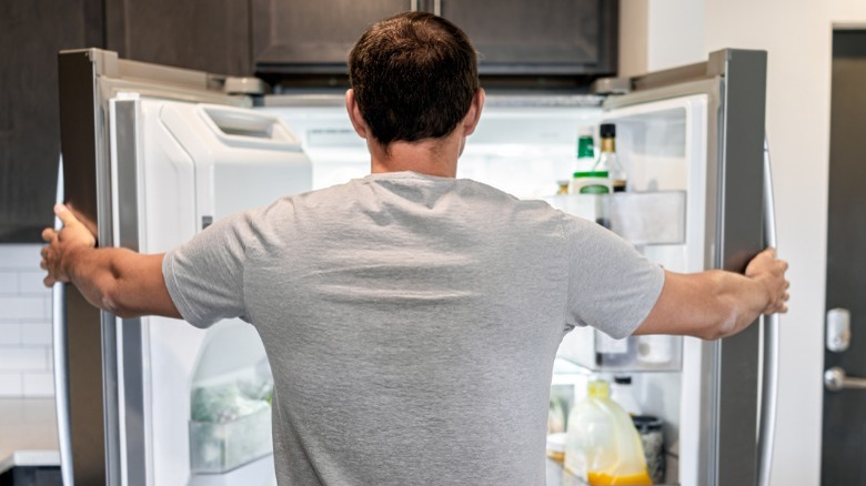 Man looking into open fridge